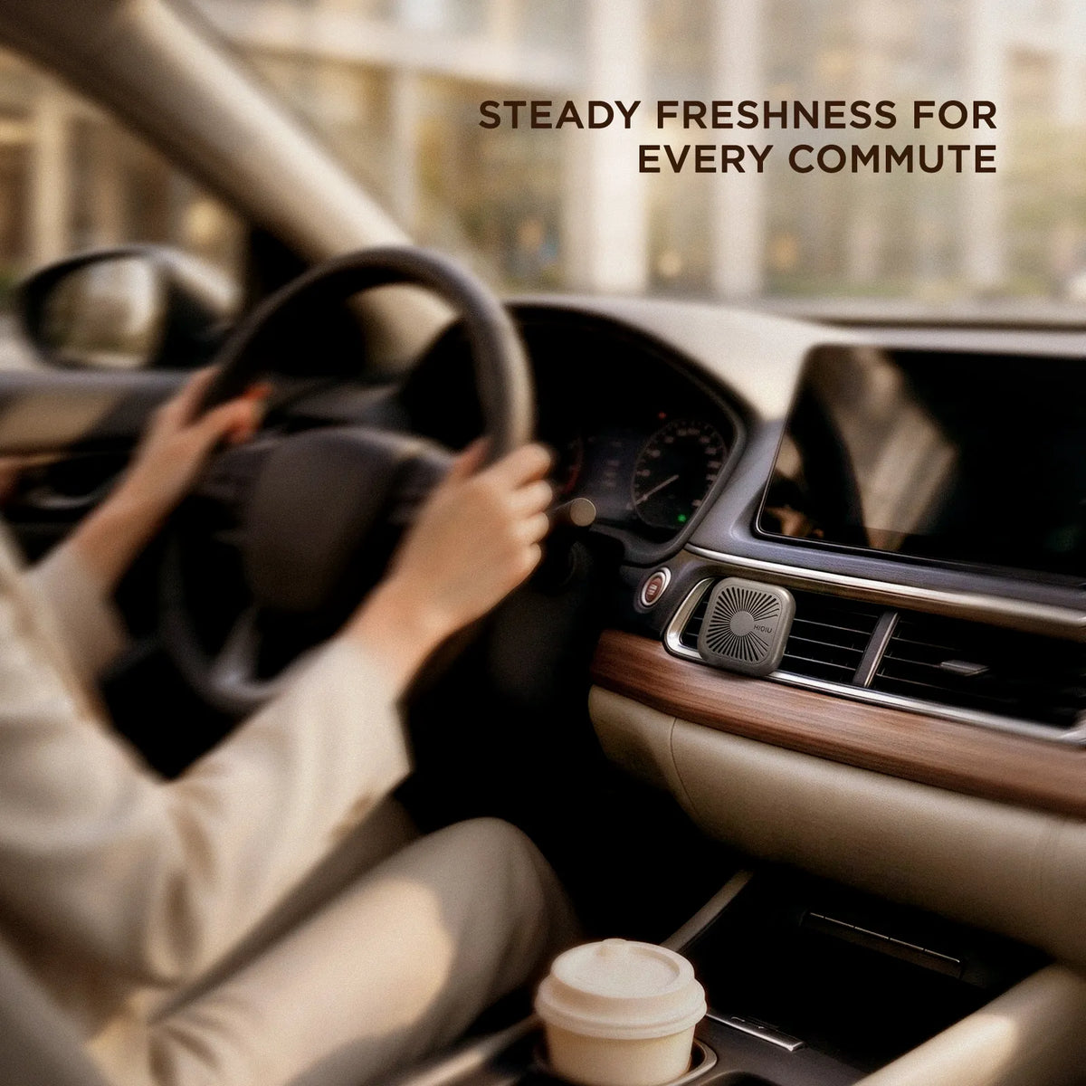 Vent air freshener clipped to a center console blower while a driver holds the wheel on a morning commute