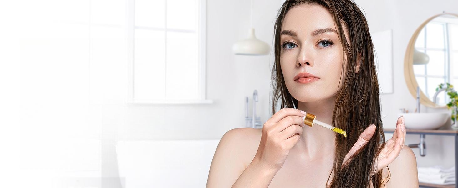 Young woman applying pure lavender essential oil to her damp hair and scalp for a natural, nourishing hair care routine.