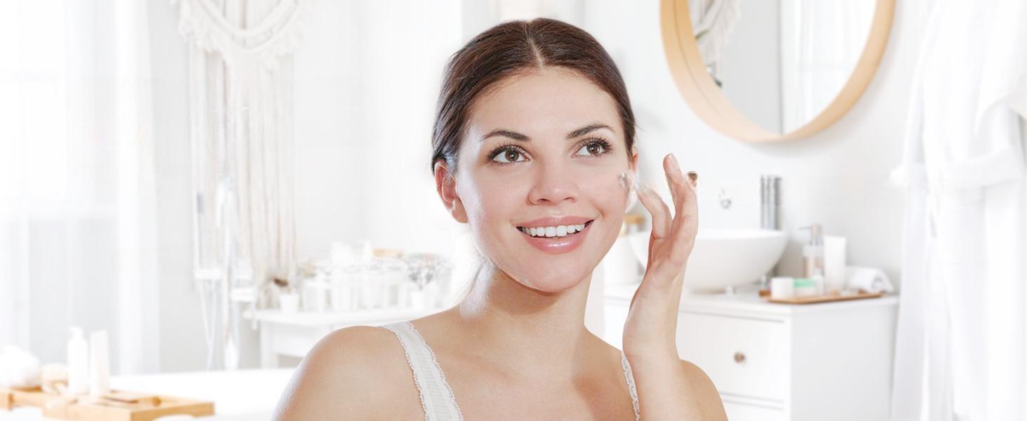Smiling woman applying diluted pure lavender essential oil to her face for a soothing, hydrating, and balancing skincare routine.