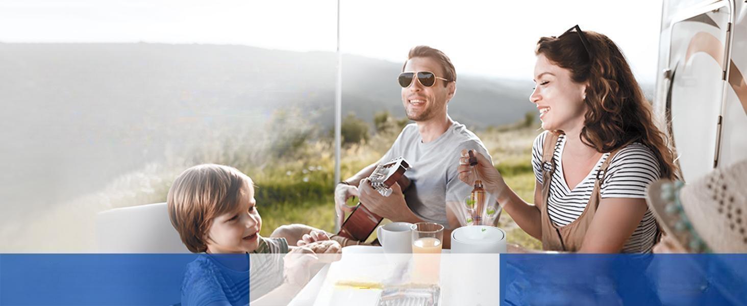 Happy family relaxing outdoors using a portable diffuser with pure tea tree essential oil to purify the air and refresh their camping space.