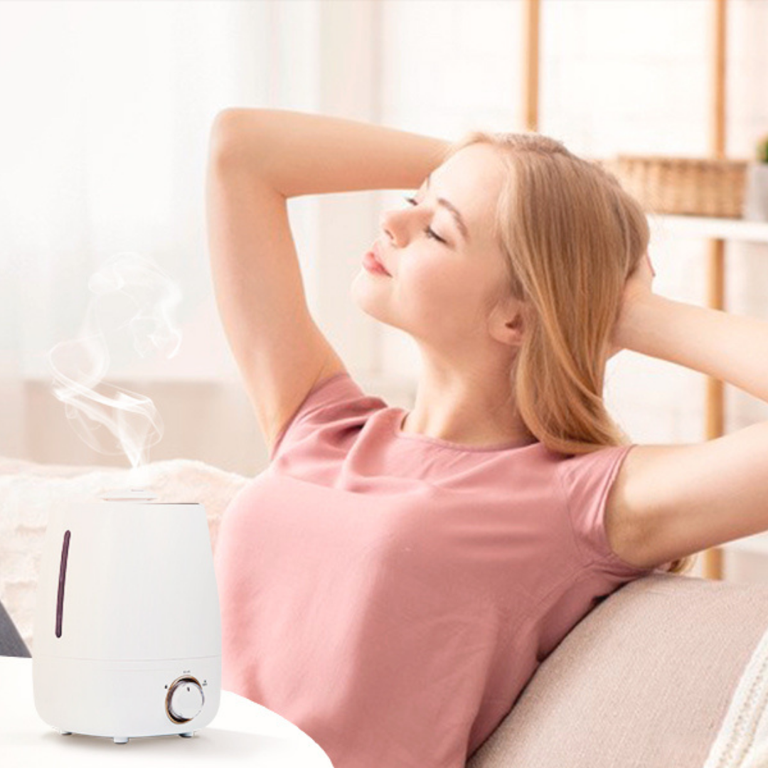 Young woman deeply relaxing on a sofa beside a white diffuser misting pure sandalwood essential oil, creating a grounding, warm, and woody aromatherapy oasis.