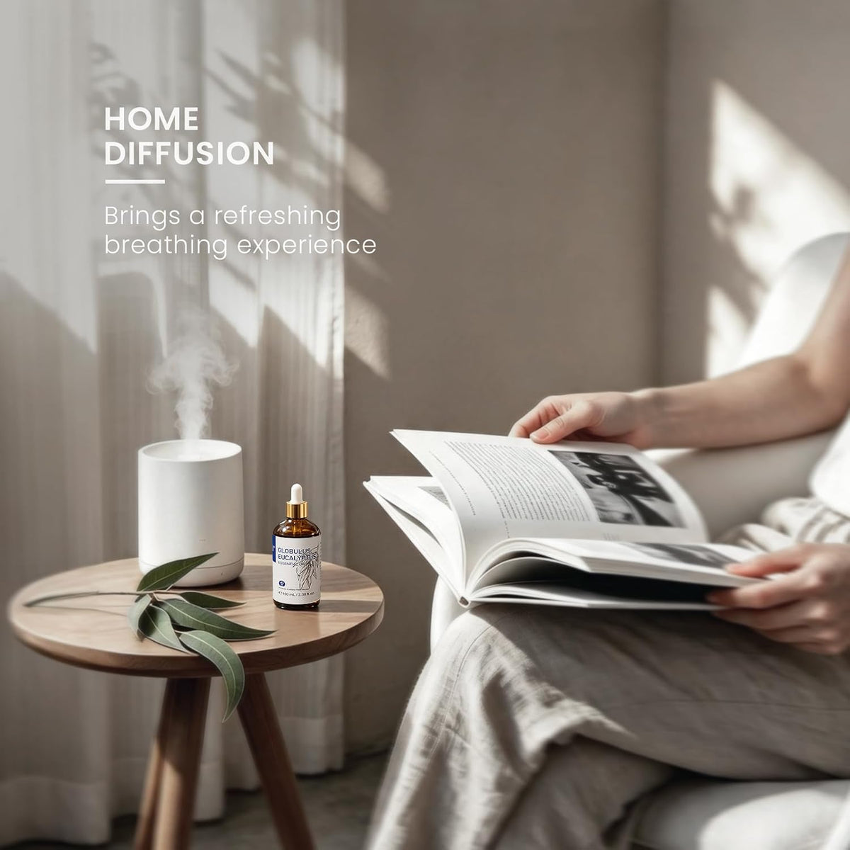 Person reading on a sofa beside a diffuser using HIQILI Globulus Eucalyptus Essential Oil