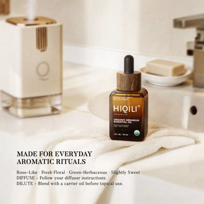 HIQILI organic geranium essential oil on a bathroom shelf beside a roller bottle and a soap dish