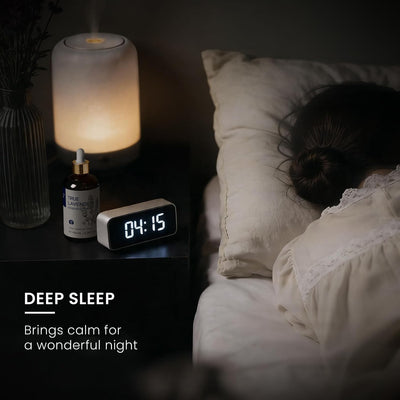 Bedside lamp and clock beside a sleeping person, illustrating HIQILI True Lavender Essential Oil for rest