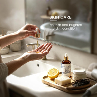 Hands at a sink adding lemon essential oil to a skin care blend