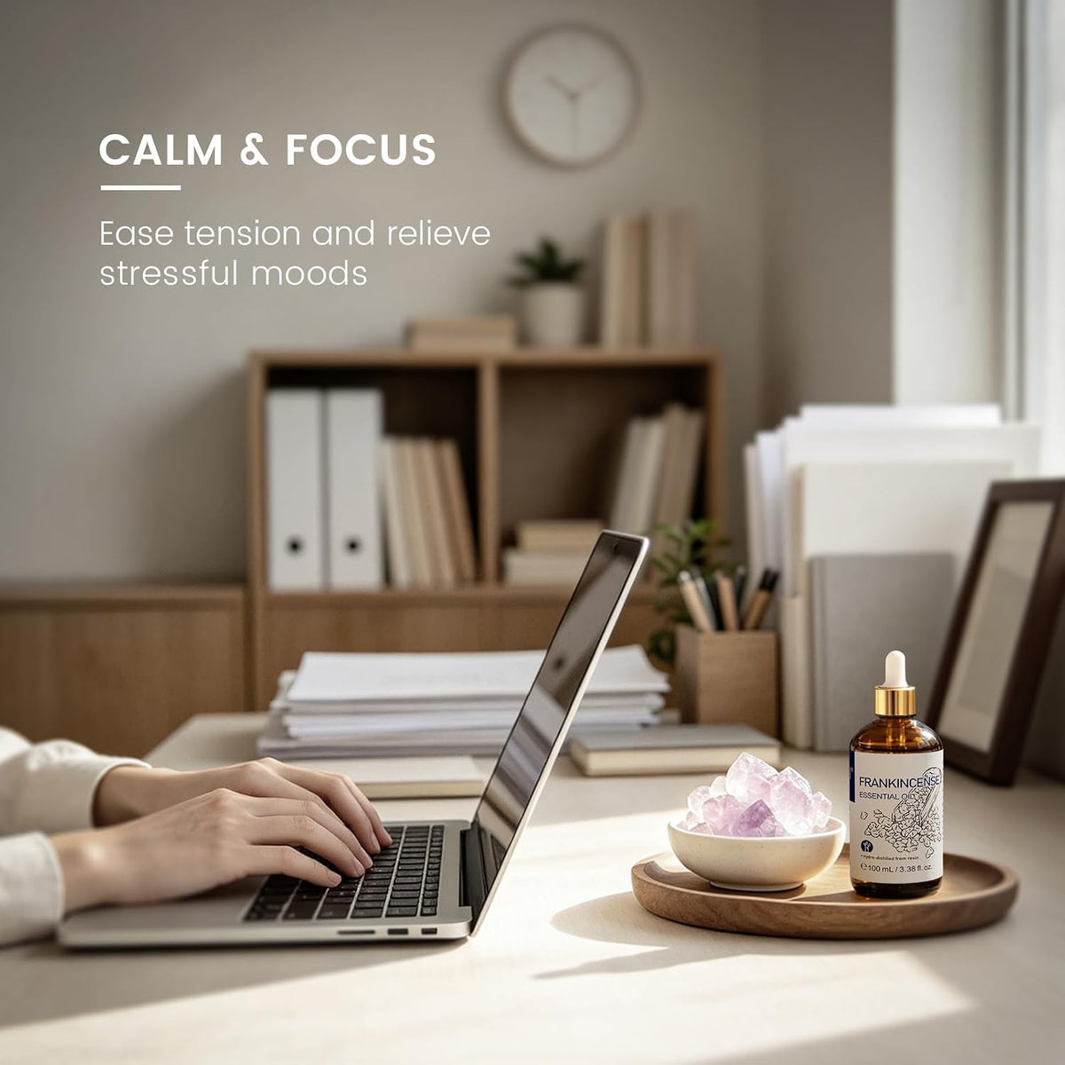 Woman working at a desk with a frankincense essential oil diffuser for calm and focus