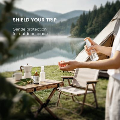 Person using an outdoor mist spray beside HIQILI Lemon Eucalyptus Essential Oil at a lakeside campsite.