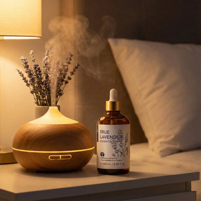 HIQILI 100ml (3.38 fl oz) True Lavender Essential Oil in Amber Bottle with Gold Dropper Next to an Operating Wood Grain Diffuse