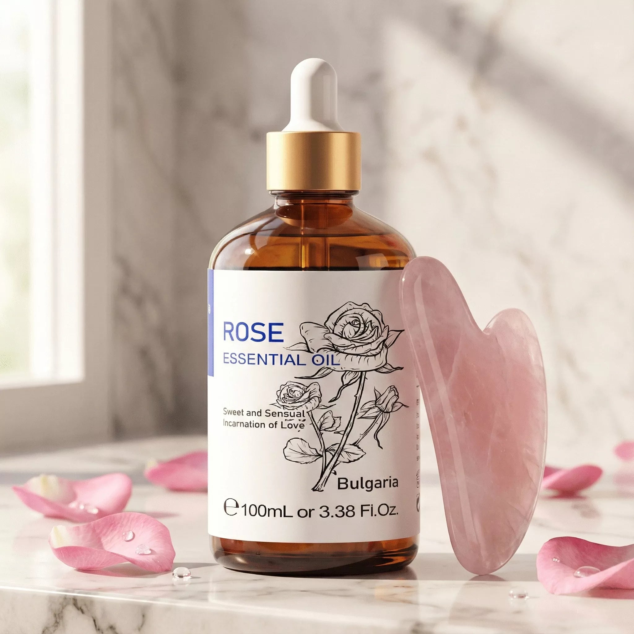 A bottle of Rose Essential Oil next to a pink quartz gua sha tool and fresh rose petals on a marble vanity, representing a luxury anti-aging skincare routine.