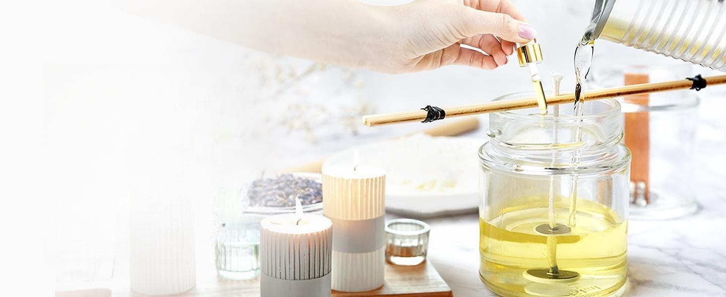 Woman making homemade scented candles by pouring melted wax and adding pure vanilla essential oil into a glass jar.