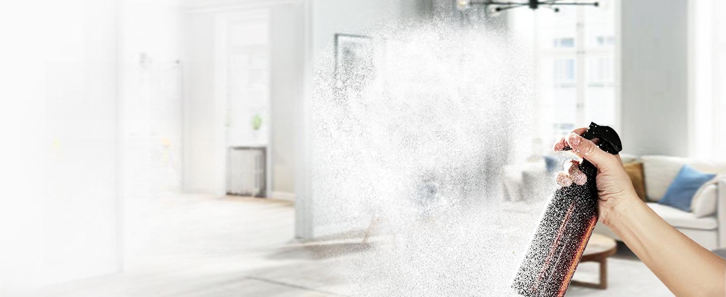 Hand spraying a homemade DIY vanilla essential oil room spray in a bright, cozy living room for a natural, chemical-free air freshener.